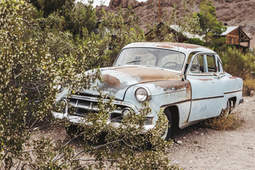 Old vintage rusty car truck abandoned in the desert
