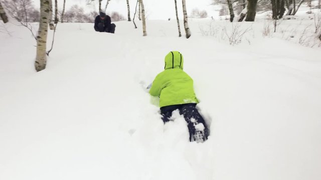 Winter follow little child walking to father playing with snow in snowy field. Family people have fun together outdoors.Childhood concept. 4k video