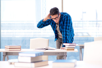Student studying in the empty library with book preparing for ex