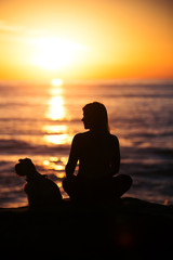 Siluet, silhouette, shadow of dog and woman, girl meditate, yoga at beach. California sunset