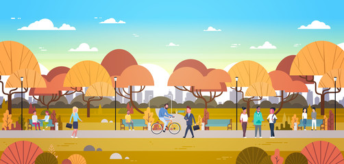Obraz premium People Relaxing Outdoors In Autumn Urban Park Over City Skyline Background Walking Riding Bicycle And Communicating Flat Vector Illustration