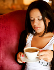 young woman sitting in a cafe drinking coffee