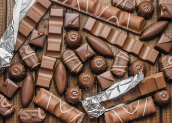 Background of chocolates, bars and sweets, free space for text, close up