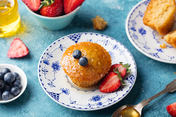 Muffin, cake with fresh berries on a plate. Blue background
