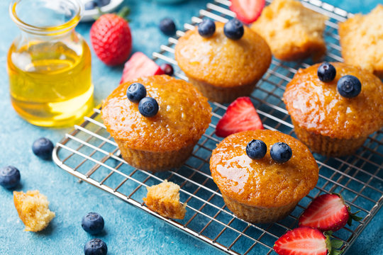 Muffins,cakes with fresh berries and honey on cooling rack