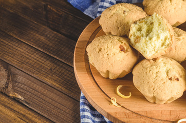 Lemon cupcakes on a wooden Board on the table with a blue towel.