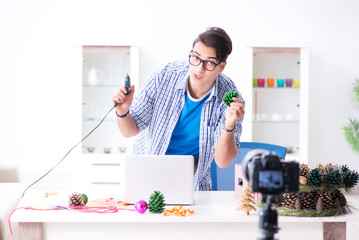 Young vlogger recording video doing christmas decoration