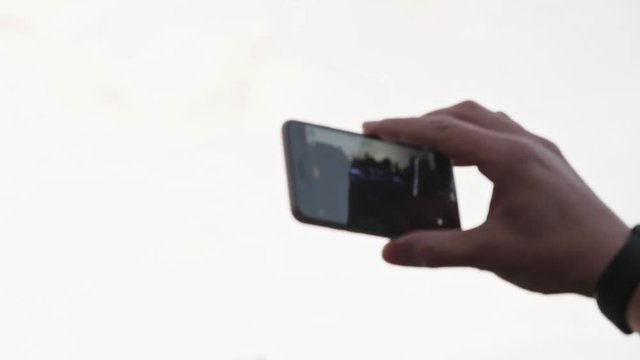Unrecognizable hands taking photo or recording video of live music concert with smartphone outdoors. Photography, entertainment and technology concept