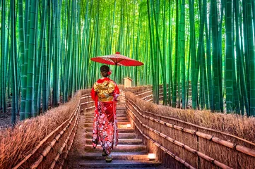 Foto op Plexiglas Bamboo Bos. Aziatische vrouw die Japanse traditionele kimono draagt bij Bamboo Forest in Kyoto, Japan. © tawatchai1990
