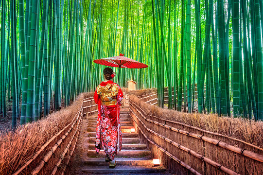 Las Bambusowy. Azjatycka kobieta jest ubranym japońskiego tradycyjnego kimono przy Bambusowym lasem w Kyoto, Japonia.
