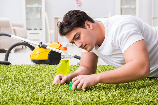 Young husband man cleaning floor at home