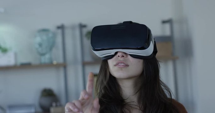 Woman in VR 360 goggles designing a home virtually - slow motion