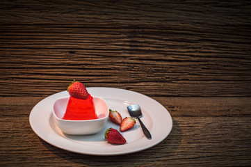 Jelly dessert with strawberries on wooden background