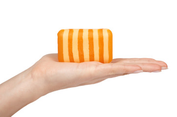 Stripped orange soar bar in hand. Isolated on white background