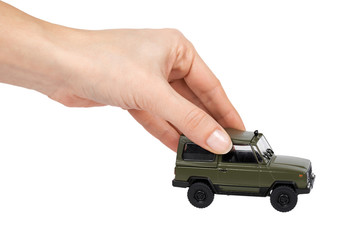 Green plastic toy SUV vehicle, offroad truck, military car, 4x4 auto in hand. Isolated on white background