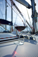 a glass of red wine on the deck of the yacht