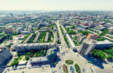 Aerial city view with crossroads and roads, houses, buildings, parks and parking lots, bridges. Urban landscape. Copter shot. Panoramic image.