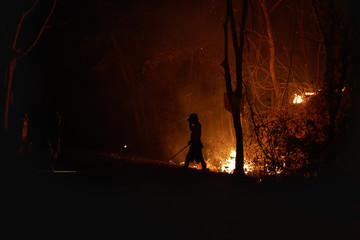 Night time capture in Northern Thailand of local farmers burning forest on purpose. Couldn't do anything with disaster. Human relations and nature concept. Stop smoke in Chiang Mai campaign.