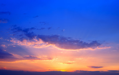 Beautiful colorful sunset sky background with the light of sun behind.Blue and purple clouds.