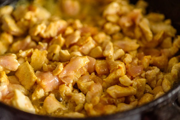 small chicken pieces are fried in a frying pan