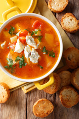 buffalo soup with chicken, vegetables and blue cheese closeup in the pan and toasted bread. vertical top view