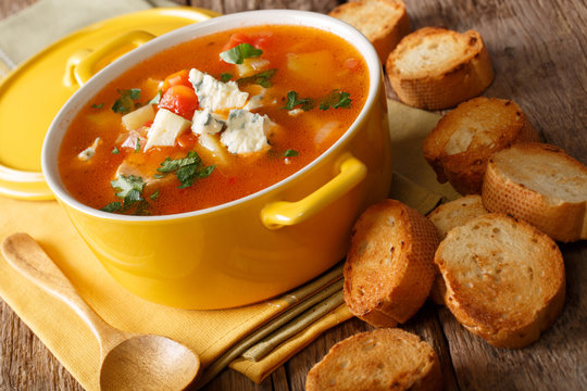 Homemade spicy buffalo soup with chicken, vegetables and blue cheese closeup in a pan and crostini. horizontal