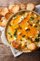 chicken buffalo dip with blue cheese and greens close-up in a baking dish. vertical top view