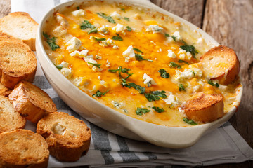 chicken buffalo dip with blue cheese and greens close-up in a baking dish on a table. horizontal