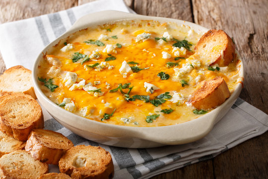 American food: hot chicken buffalo dip close-up in a baking dish with toasted bread. horizontal