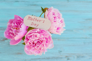 Spring-summer flowers, peonies on a light, wooden background. Greeting card with space for text. Concept for graphic design.