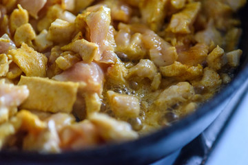 small chicken pieces are fried in a frying pan