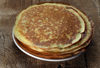 Pancakes in a plate on a wooden table