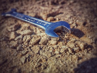 a shabby wrench on the sand