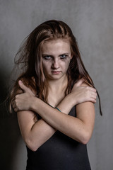Naklejka premium Scared and sad teen girl is clasping his shoulders