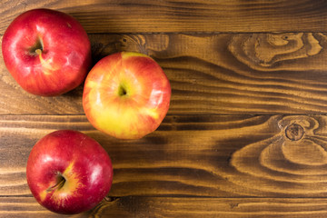 Red apples on wooden table. Top view, copy space