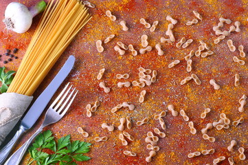 Garlic, green parsley, pasta and spices on a wooden table