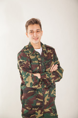 A young guy wearing a camouflage uniform. Military man on white background.
