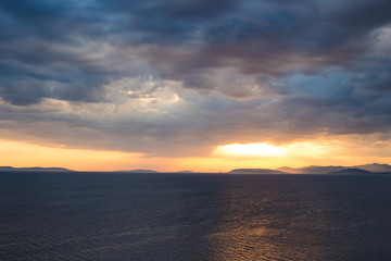 Naklejka na ściany i meble Sunset over the sea with a dramatic sky