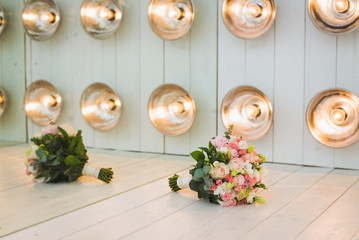 A luxurious wedding bouquet, with fresh roses in studio decorations, amid a series of light bulbs. Place for your text.