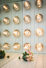 A luxurious wedding bouquet, with fresh roses in studio decorations, amid a series of light bulbs. Place for your text.