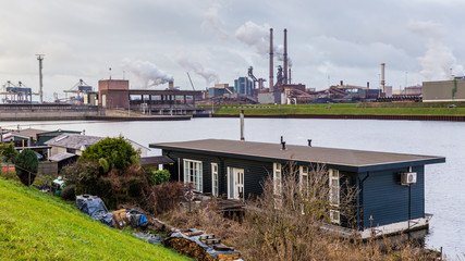 Fototapeta na wymiar Steelmaking industry plant and houseboats in IJmuiden in the Netherlands