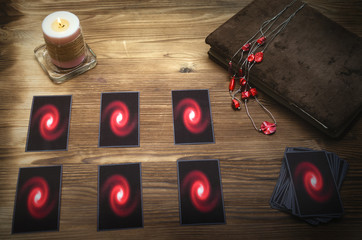 Tarot cards deck and book of magic on fortune teller desk table background. Future reading concept.