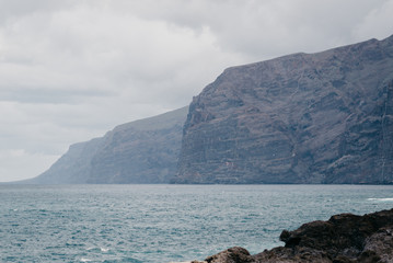 Los Gigantes cliffs with black volcanic rocks on the front. Tenerife
