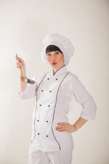 Young girl in the clothes of the cook. Confectioner on a white background.