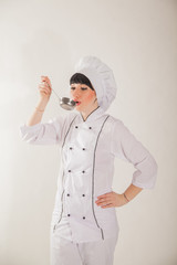 Young girl in the clothes of the cook. Confectioner on a white background.