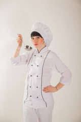 Young girl in the clothes of the cook. Confectioner on a white background.