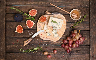 Roquefort  or Blue cheese serving with grapes, honey and figs. Cheese plate.