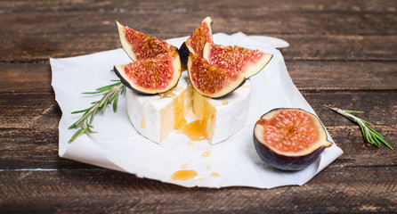 Brie Cheese on a Wooden Board with Fresh Figs and Honey. Selective Focus.