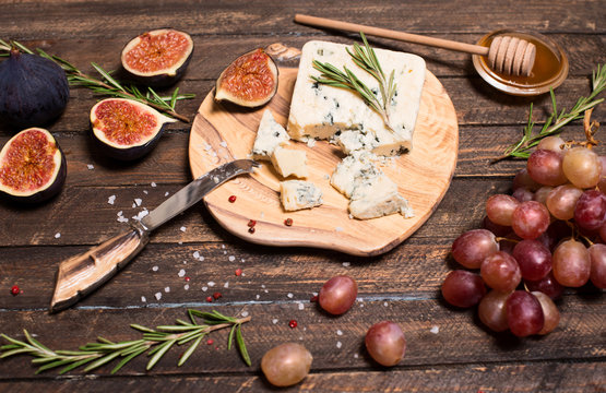 Roquefort  or Blue cheese serving with grapes, honey and figs. Cheese plate.
