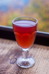 Drink in a glass. A burgundy drink in the glass. Tea made from mountain plants.